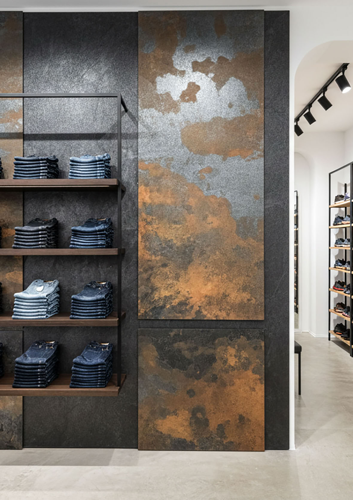 Regal mit gefalteten Jeans vor einer Wand mit Effektspachtel Smoke und Stahl und Spachtelrost.