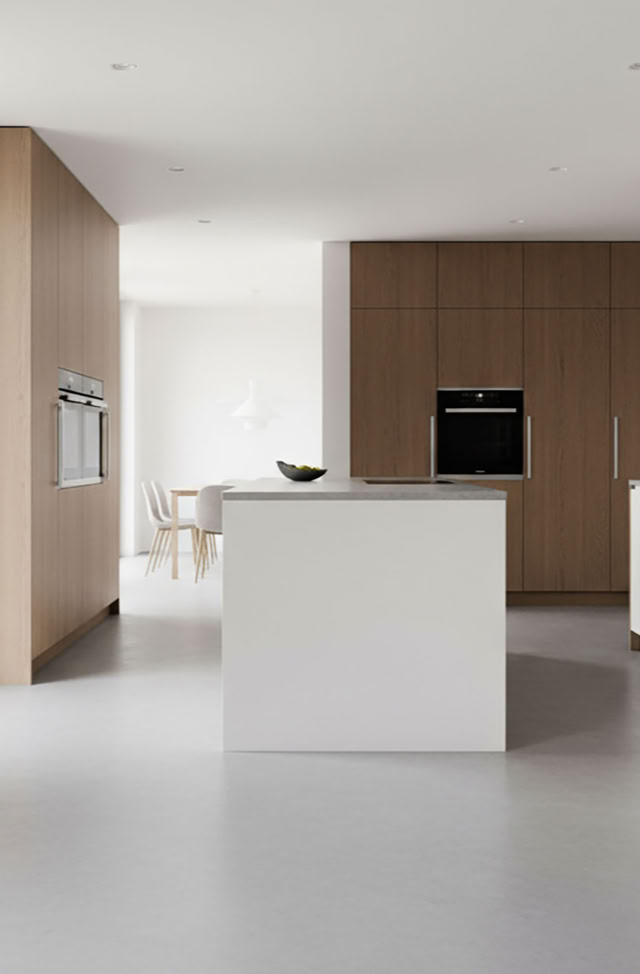 Moderne Küche, fugenloser Rexx 2K Boden von glaMUR mit weißer Kochinsel, Holzschränken, eingebautem Ofen und großen Fenstern.